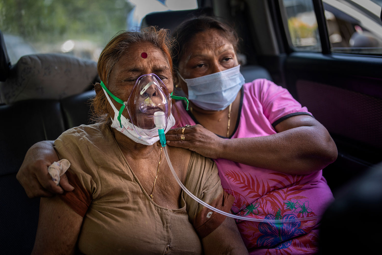 Kritisk syke koronapasienter dør på gata på grunn av mangelen på ledige sykehussenger og oksygen. Denne kvinnen får oksygen i en bil i New Delhi.